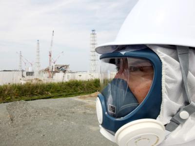 Besuch in der Todeszone: Ein mit Schutzanzug vor der radioaktiven Strahlung geschützter Journalist bei einem Besuch am havarierten Atomreaktor Fukushima. Foto: Tomohiro Ohsumi Besuch in der Todeszone