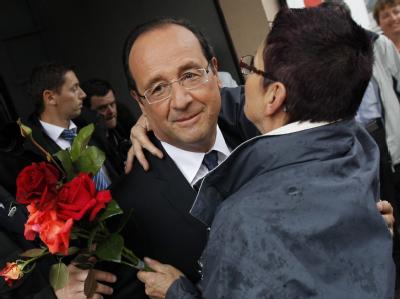 Frankreichs Präsident Hollande wird von einer Anhängerin nach seiner Stimmabgabe umarmt. Foto: Guillaume Horcajuelo Umarmung