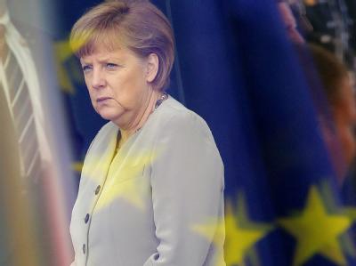 Bundeskanzlerin Merkel im Foyer des Bundeskanzleramtes in Berlin: Das Foto wurde durch die Scheiben des Kanzleramtes aufgenommen, in denen sich die Flagge der EU spiegelt. Foto: Wolfgang Kumm Angela Merkel