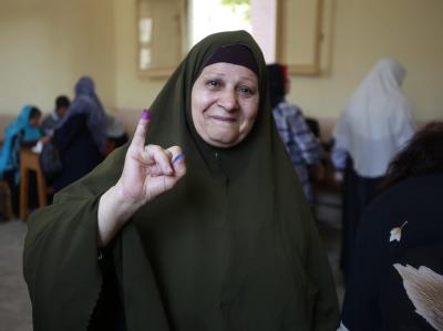 Gewählt! Eine Ägypterin hält ihren in Tinte getauchten Finger nach ihrer Stimmabgabe hoch. Foto: Andre Pain Gewählt!