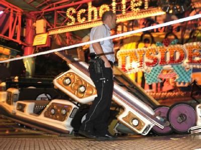 Ein Polizist sichert die Unfallstelle auf der Kirmes in Gevelsberg: Aus noch ungeklärter Ursache hatte sich eine Gondel von einem Fahrgeschäft auf gelöst. Sieben Menschen wurden verletzt. Foto: Holger Battefeld Unfall auf Kirmes