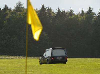 Ein Leichenwagen auf dem Fairway des Golfplatzes Waldeck. Drei Golferinnen wurden hier vom Blitz erschlagen. Foto: Uwe Zucchi Leichenwagen