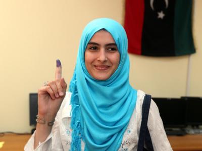 Eine Frau zeigt ihren gefärbten Finger als Zeichen für ihre vollzogene Wahl. Foto: Sabri Elmhedwi Gewählt!