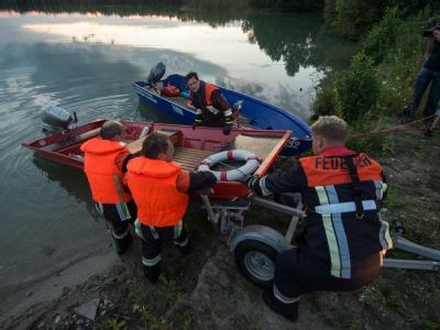 Einsatzkräfte schieben ein Boot in den Mittleren Klausensee bei Schwandorf (Oberpfalz) um nach einem Krokodil zu suchen. Foto: Armin Weigel Jagd auf Krokodil in der Dunkelheit