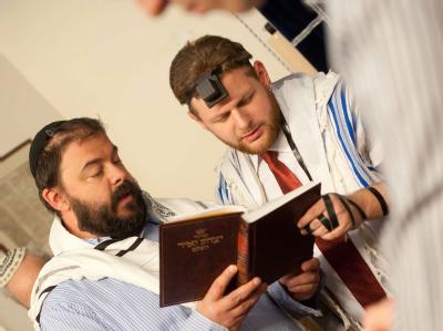 Rabbiner beten bei der jüdischen Beschneidungszeremonie für einen acht Tage alten Jungen. Das Landgericht Köln hat das Beschneidung als Körperverletzung gewertet. Foto: Bea Kallos/ Archiv Beschneidung