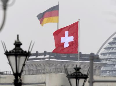 Deutschland und die Schweiz haben ein Steuerabkommen ausgehandelt. Kritiker monieren trotz Nachbesserungen eine Benachteiligung der Steuerehrlichen. Foto: Rainer Jensen Schweizer Flagge vor dem Reichstag in Berlin