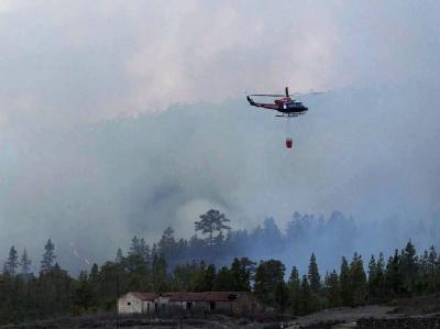 Ein Löschhubschrauber überfliegt die Ortschaft Arona im Süden Teneriffas. Foto: Ramon De La Rocha Löschhubschrauber über Teneriffa