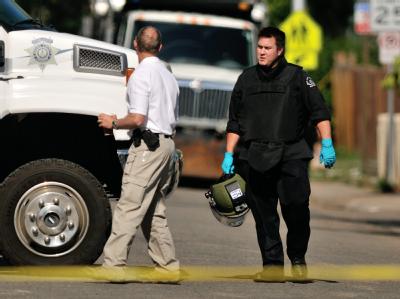 In schwerer Schutzkleidung verlässt ein Sprengstoffexperte das Apartment des mutmaßlichen Killers James Holmes in Aurora. Foto: Bob Pearson Bombenexperte
