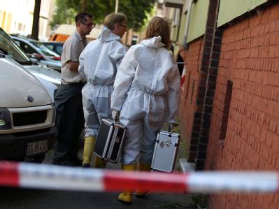 Polizisten und Kriminaltechniker auf dem Weg in die ausgebrannte Wohnung. Foto: Oliver Berg Familientragödie in Dortmund
