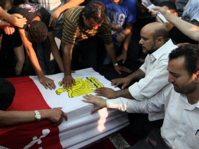 Verwandte und Freunde trauern an dem Sarg eines der 16 Getöteten. Foto: Khaled Elfiqi Bestattung