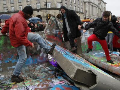 Teilnehmer eines Happenings in Warschau trampeln symbolisch die Mauer nieder. Polen feiert 20. Jahrestag des Mauerfalls