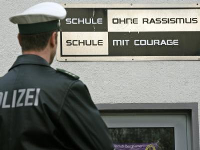 Ein Polizist steht vor der Heideschule in Bergkamen. Schule in Bergkamen