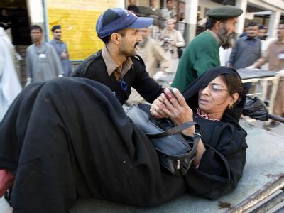 Eine verletzte Frau wird nach dem Anschlag in eine Klinik gebracht. Anschlag in Peshawar