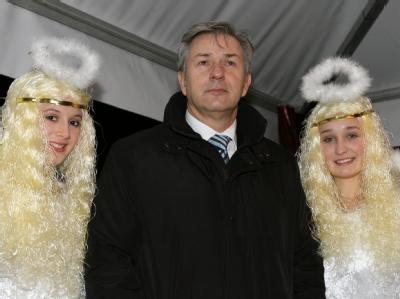 Der himmlische Beistand hat nichts genützt: Der Regierende Bürgermeister von Berlin, Klaus Wowereit, mit zwei Engeln bei der Eröffnung des Weihnachtsmarktes vor dem Roten Rathaus. Himmlischer Beistand