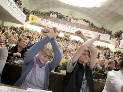 Studenten symbolisieren mit überkreuzten Armen im Audimax der Ludwig-Maximilians-Universität in München, dass sie nicht der Meinung des Redners sind. Bildungsstreik
