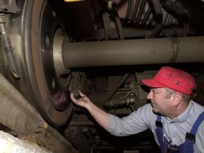 Ein Bahn-Mitarbeiter überprüft die Achse eines ICE-T (Archivfoto). ICE-Wartung