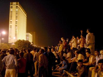 Menschen beobachten das Geisel-Drama im Luxushotel «Oberoi Trident» in Bombay (Foto vom 27.10.2008). Trident-Hotel