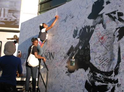 Alicia Gordon schreibt Abschiedsworte auf das Riesenposter vor dem Staples Center in Los Angeles. Ansturm der Jackson-Fans am Staples Center