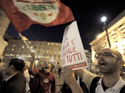 Ein Demonstrant vor dem Palazzo Chigi in Rom hält ein Poster mit dem Spruch Demonstration