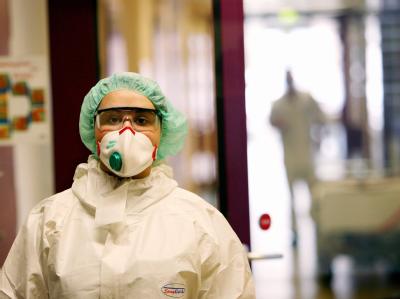Eine Krankenschwester verlässt durch eine Schleuse die Infektionsstation eines Krankenhauses. Infektionsstation