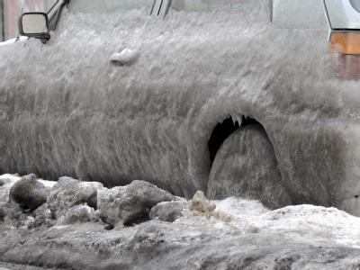Unter einem dicken Panzer aus Eis, Dreck und Schnee steht ein Auto bei minus zwölf Grad in Berlin am Straßenrand. Auto unter Eispanzer