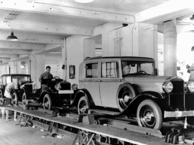 Das Archivbild von 1924 zeigt Arbeiter der Opel-Werke am Fließband. Produktion bei Opel 1924