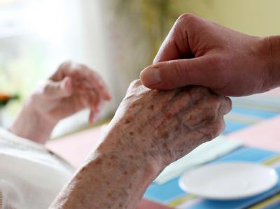 Pflegeexperte: Altenpflege für Azubis attraktiv machen. Foto: Oliver Berg/Archiv Ein Altenpfleger hält die Hand einer Patientin
