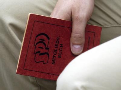 Ein SPD-Anhänger hält sein Parteibuch in der Hand. Foto: Archiv SPD-Parteibuch