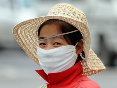 Der Preis des Wachstum: Eine Pekinger Straßenfegerin schützt sich gegen die Luftverschmutzung (Archivfoto vom 29.7.2008). Smog in China
