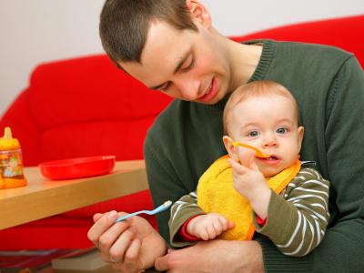 Ein junger Vater füttert seinen Sohn: Mehr als jeder vierte Vater eines neugeborenen Kindes geht inzwischen in Elternzeit. Foto: Uwe Anspach/Archiv Vater in Elternzeit