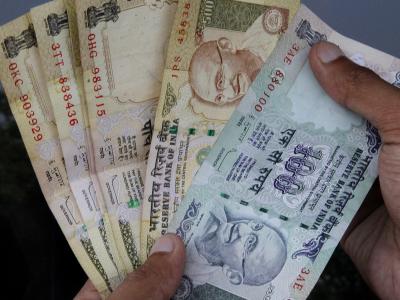 Ein Politiker der indischen marxistischen Partei hat sich einen Traum erfüllt - und in einem Bett aus Geld geschlafen. Foto: epa/str/Illustration Indische Rupie