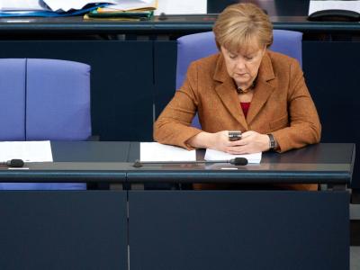 Bundeskanzlerin Angela Merkel (CDU) schaut während einer Sitzung des Bundestags auf ihr Mobiltelefon. Foto: Maurizio Gambarini/Archiv Angela Merkel