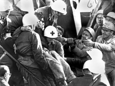 Helfer tragen während der dramatischsten Rettungsaktion in der Geschichte des deutschen Bergbaus in Lengede einen der befreiten Bergleute ins Freie. Foto: Archiv Überlebender