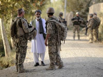 Ein Bundeswehrsoldat (l) und ein Dolmetscher (r) sprechen bei Kundus mit einem afghanischen Mann. Foto: Maurizio Gambarini/Archiv Dolmetscher der Bundeswehr in Afghanistan