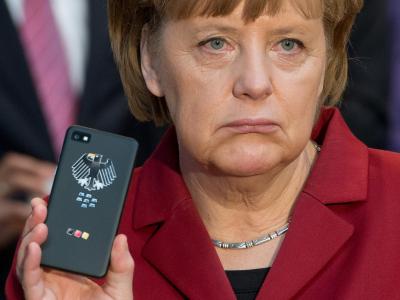 Angela Merkel mit einem Blackberry-Smartphone auf der Computermesse CeBIT. Foto: Julian Stratenschulte/Archiv Merkels Handy