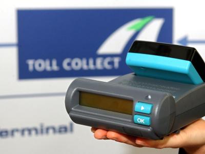 Ansicht eines Gerätes zur Erfassung von LKW-Mautgebühren vor dem Logo des Unternehmens Toll Collect. Foto: Tim Brakemeier Toll Collect GmbH