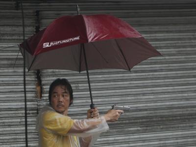 Ein Ladenbesitzer verteidigt in Tacloban sein Geschäft mit einer Pistole gegen Plünderer. Foto: Francis R. Malasig Ladenbesitzer