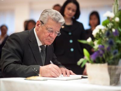 Bundespräsident Joachim Gauck trägt sich in das Kondolenzbesuch in der philippinischen Botschaft ein. Foto: Guido Bergmann Bundespräsident Gauck kondoliert