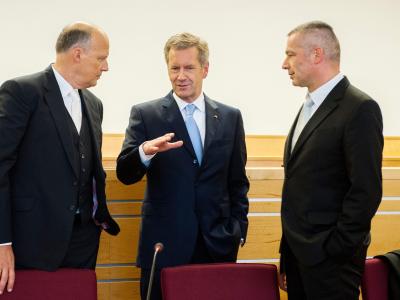 Christian Wulff berät sich im Gerichtsaal mit seinen Anwälten. Foto: Hauke-Christian Dittrich / Pool Wulff mit seinen Anwälten