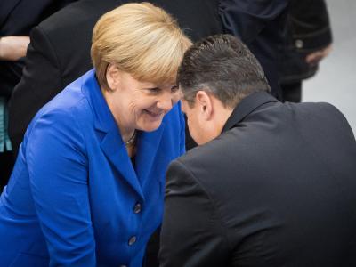 Kanzlerin Merkel und SPD-Chef Gabriel unterhalten sich im Bundestag. Foto: Michael Kappeler Gabriel und Merkel