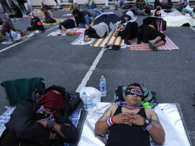 Die Lage bleibt angespannt in Bangkok. Tausende Demonstranten campieren über Nacht draußen. Sie wollen Thailands Regierung stürzen. Parallel stellt die Opposition einen Misstrauensantrag im Parlament. Foto: Barbara Walton Demonstranten campieren im Freien