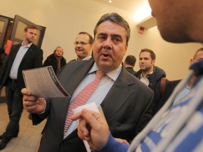 Sigmar Gabriel hält in der Stadthalle in Hofheim am Taunus einen Flyer mit der Aufschrift Gabriel