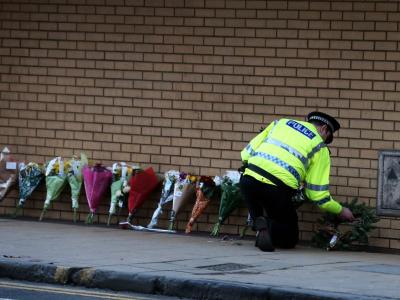 Ein Polizist legt in Glasgow Blumen für die Pfer nieder. Foto: Andrew Milligan Trauer