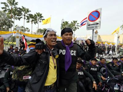 Lächeln und Umarmungen statt Brandsätzen und Tränengas: Thailands Polizei hat die Taktik geändert. Foto: Mast Irham Arm in Arm