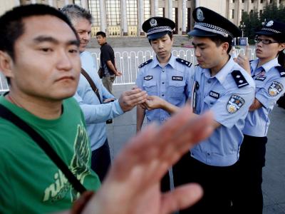 Ein Polizist in Zivil versucht, Journalisten auf dem Tian'anmen-Platz in Peking davon abzuhalten, die Kontrolle eines Kameramanns durch Uniformierte zu fotografieren. China demonstriert seine Macht gegenüber ausländischen Journalisten. Zwei Dutzend Korres Journalisten droht Ausweisung aus China