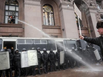Oppositionelle versuchen, aus dem Rathaus in Kiew Polizisten nass zu spritzen. Foto: Roman Pilipey Verkehrte Welt