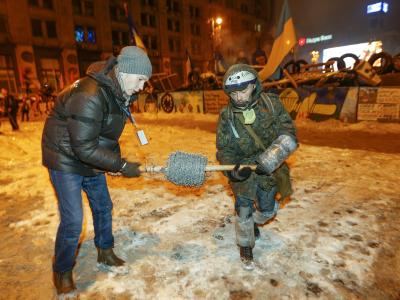 Demonstranten verstärken eine Barrikade mit Stacheldraht. Foto: Sergej Dolzhenko Stacheldraht