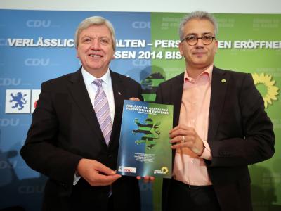 Der hessische Ministerpräsident Volker Bouffier und der hessische Vorsitzende von Bündnis 90/Die Grünen in Hessen, Tarek Al-Wazir, zeigen ein gedrucktes Exemplar ihres Koalitionsvertrages. Foto: Frank Rumpenhorst Koalitionsvertrag