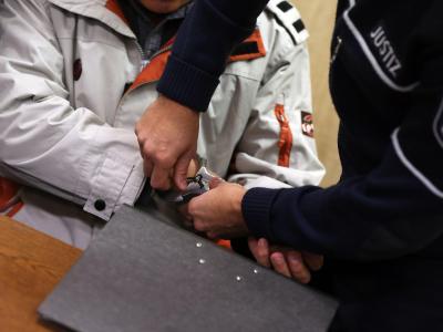 Eine Justizangestellte nimmt dem Angeklagten Mehmet D. in Köln im Gerichtssaal die Handschellen ab. Foto: Oliver Berg Prozess