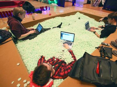 Teilnehmer des 30C3 sitzen mit ihren Laptops in einem Becken mit Verpackungsmaterial. Foto: Bodo Marks 30. Chaos Communication Congress